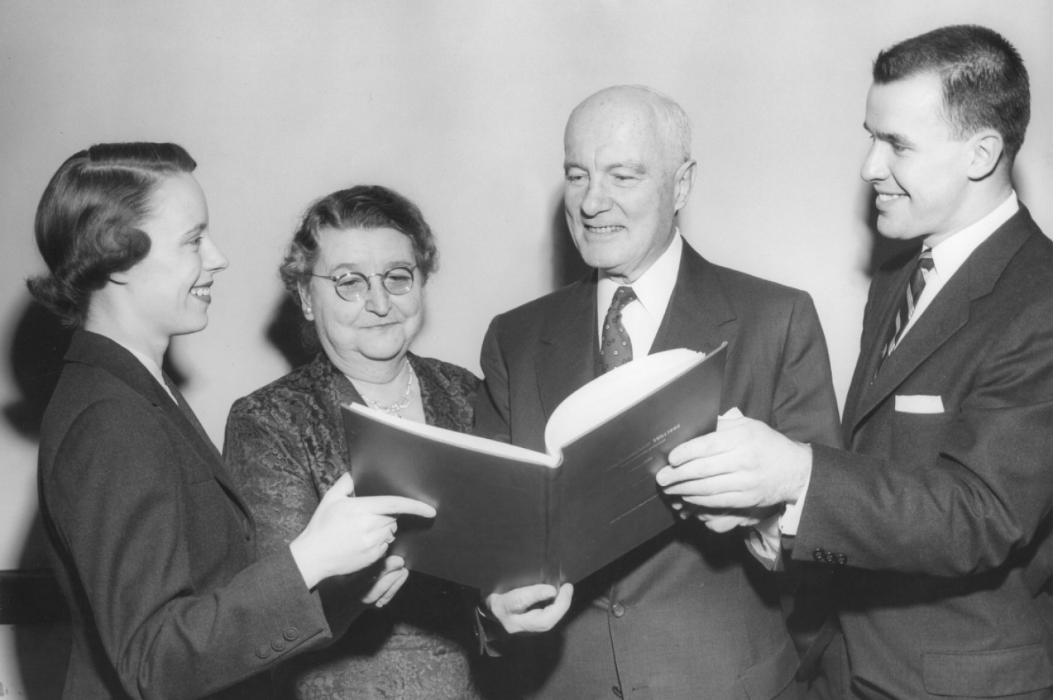 From the left: Shirley Parsons, Mrs. Raymond Walters, Dr. Raymond Walters, Otto Budig. The Walters are presented with a signature book at Raymond Walters' student-sponsored retirement dinner in 1955.