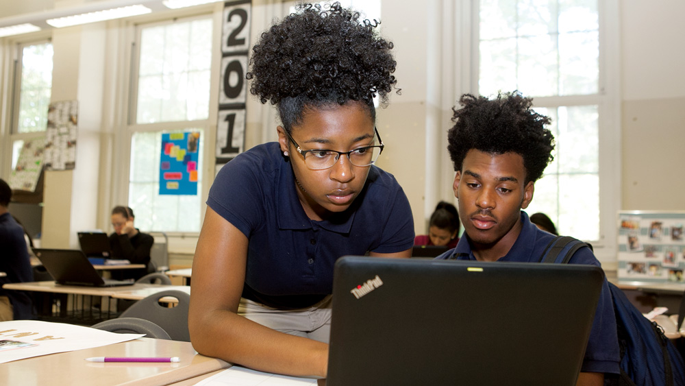 Students work together on a laptop