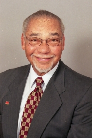 Portrait shot of a smiling Clark Beck, wearing a suit
