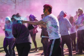 UC students throw colored powder on McMicken Commons as part of Holi Festival.
