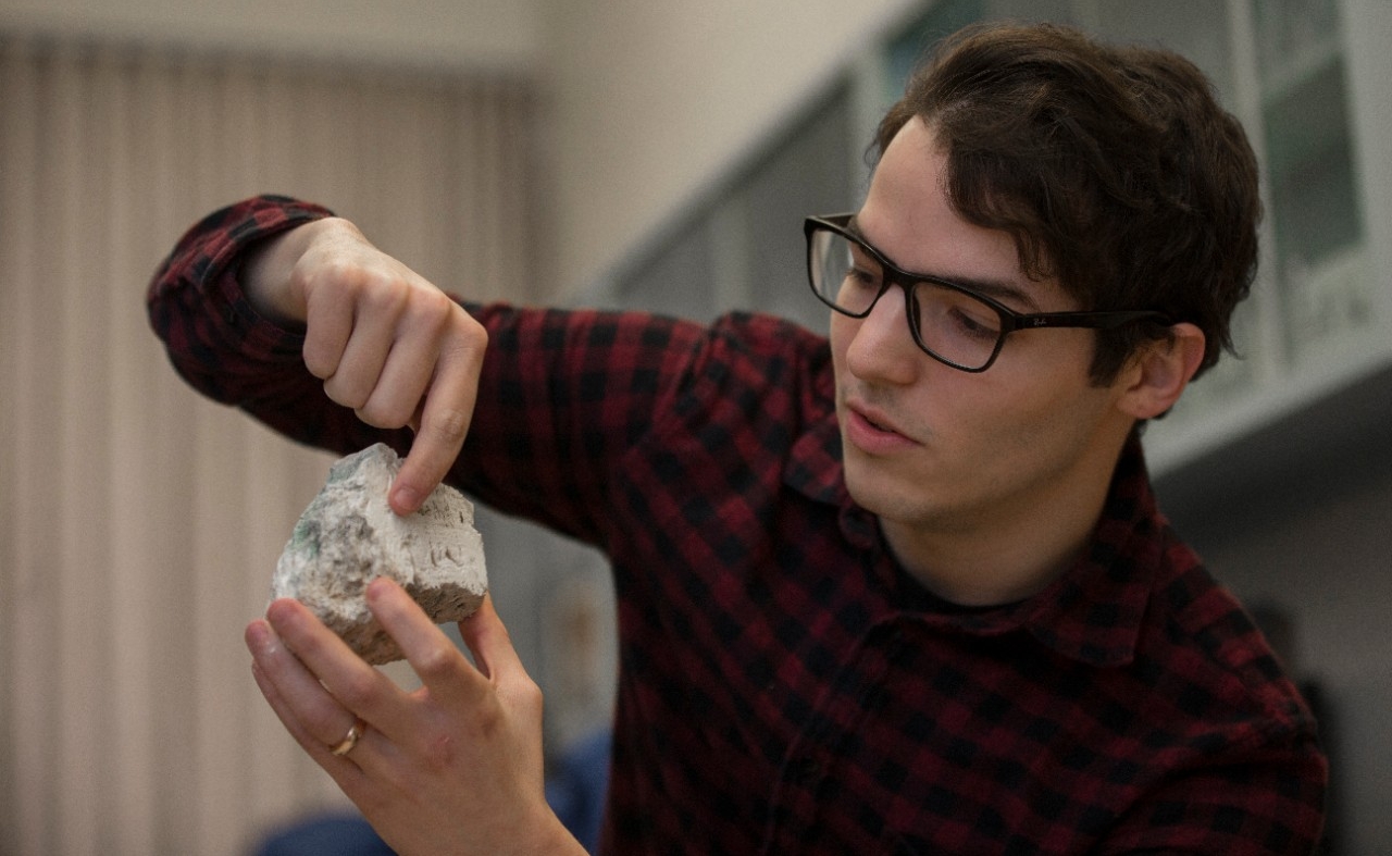 UC graduate student Andrew Gangidine holds a piece of Yellowstone silica containing bacterial life like scientists may one day find on Mars. 