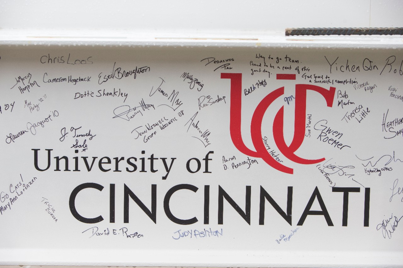 Numerous signatures adorn the final beam, which was painted white and featured the UC logo.