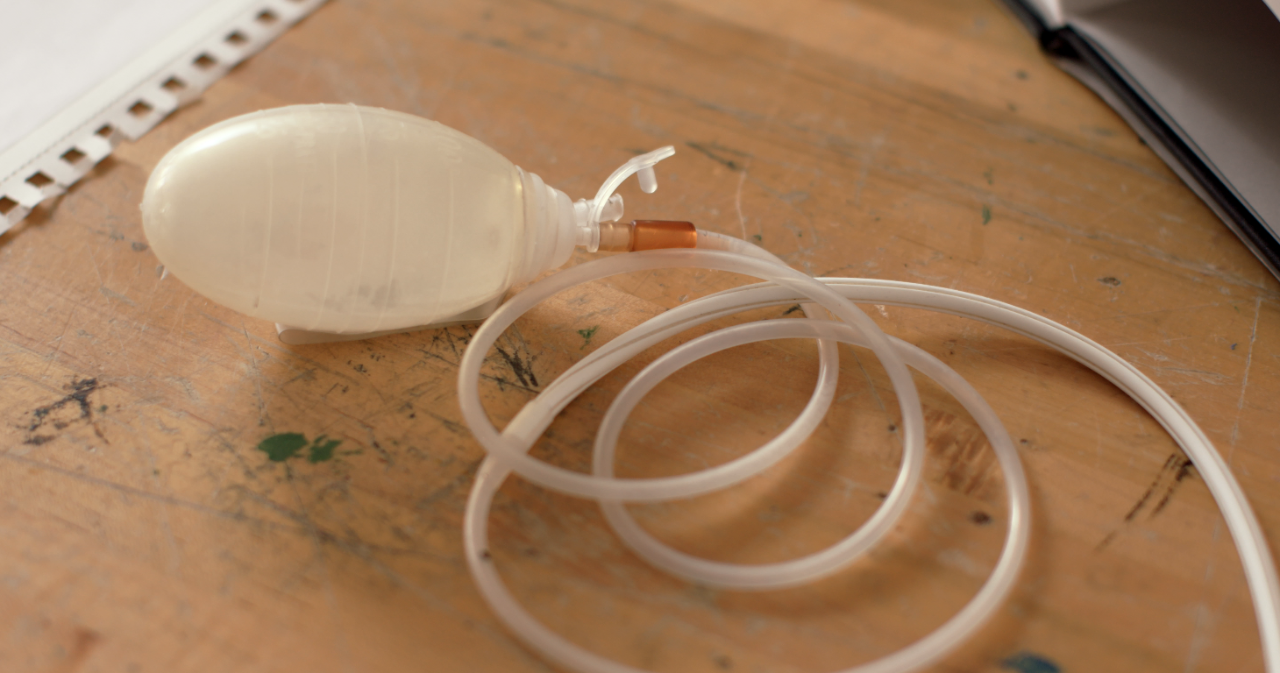 A surgical drain, comprised of a plastic bulb attached to tubing.