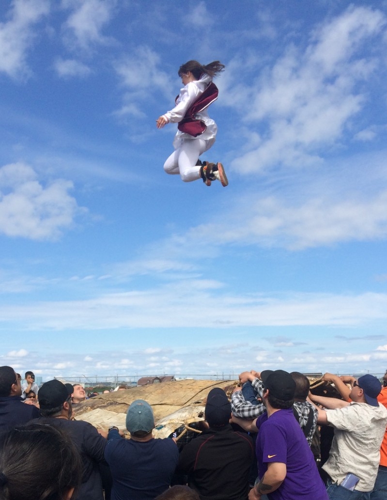 A girl in Kotzebue, Alaska, takes part in a traditional Eskimo blanket toss as part of a summer festival.