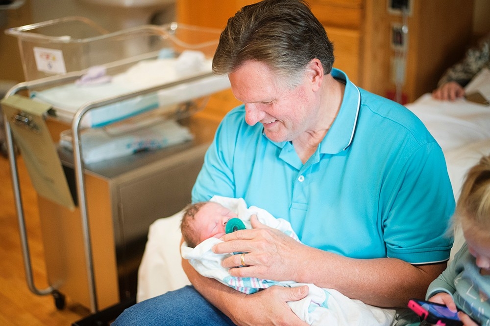 Lenny Robinson holds his grandson, Baehr, in the hospital.