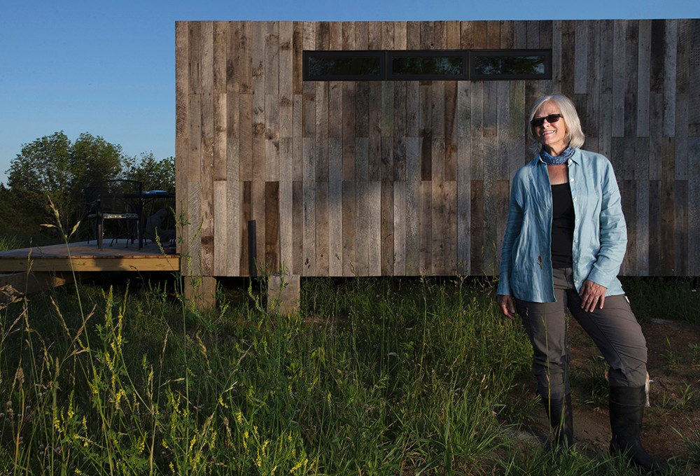 Land steward Adrienne Cassel stands in front of her tiny house on the Kamama Prairie.