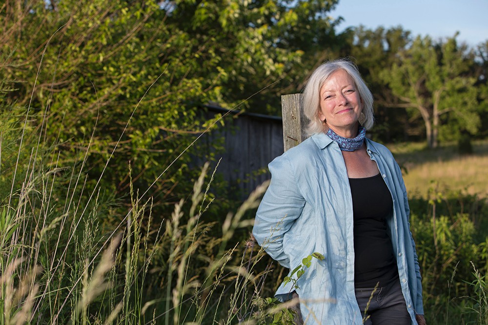 Land stewardship is an ideal form of service for Cassel, a lifelong nature lover. Photo/Andrew Higley/Creative Services Adrienne Cassel poses in the middle of the Kamama Prairie surrounded by trees and greenery.