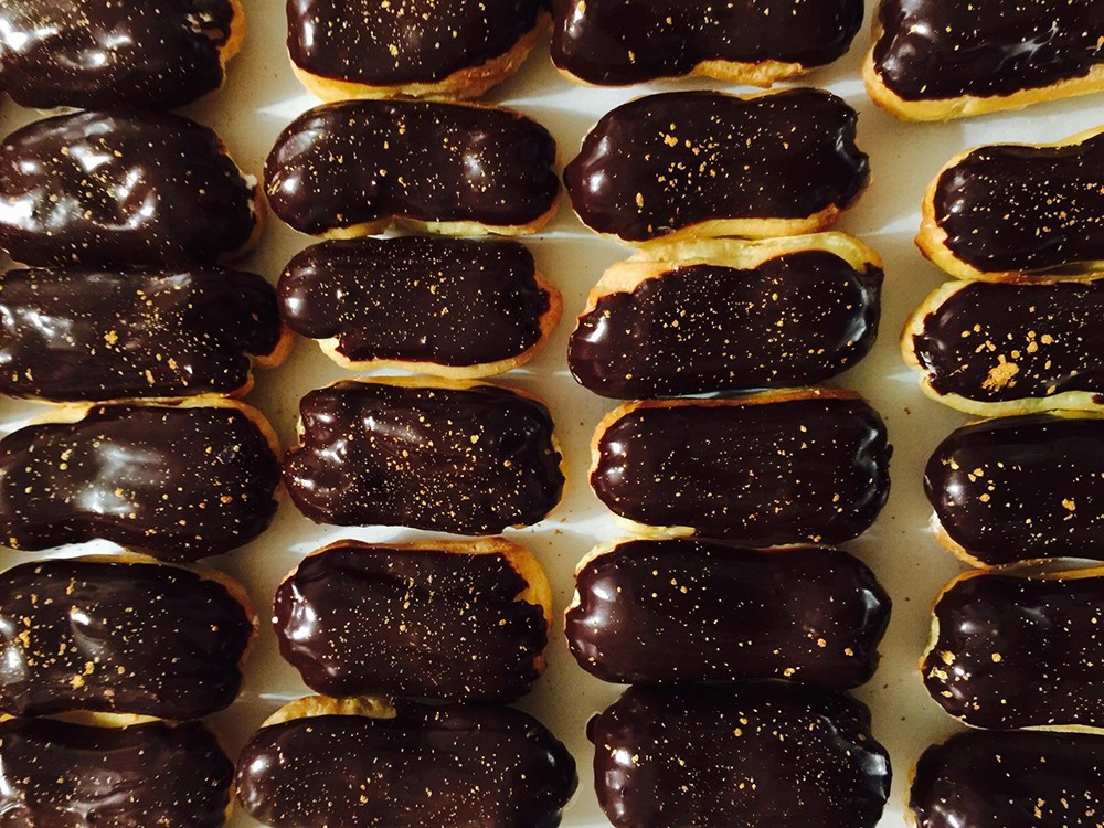 Rows of chocolate-iced eclairs made by James Avant