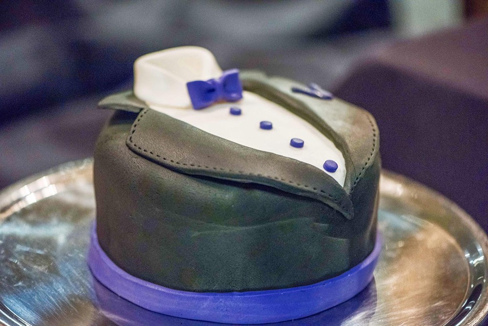 A round cake from OCD Cakes is iced to resemble a tuxedo