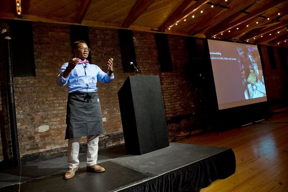 James Avant stands onstage addressing the audience at the Big Pitch competition.