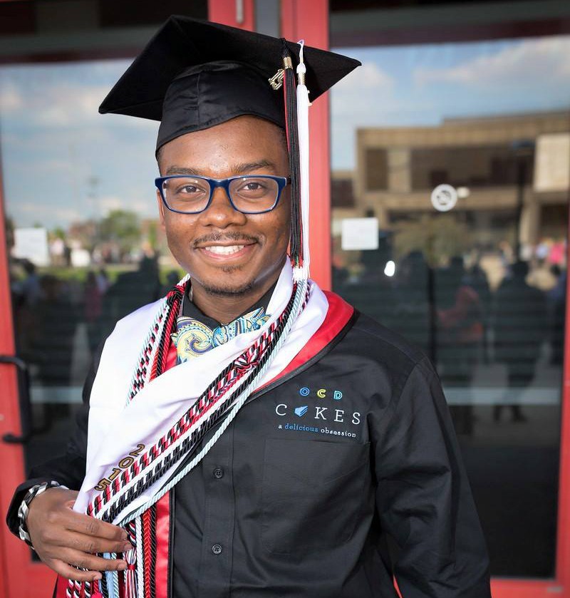 James Avant poses on his graduation day wearing an OCD Cakes chefs coat with his cap and tassels. 