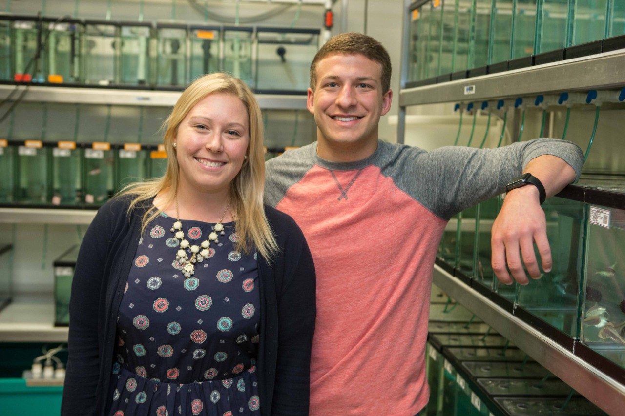 UC graduate student Amanda Powers and her co-author, UC graduate Shane Kaplan, pose in the biology lab where they keep aquariums full of cavefish.