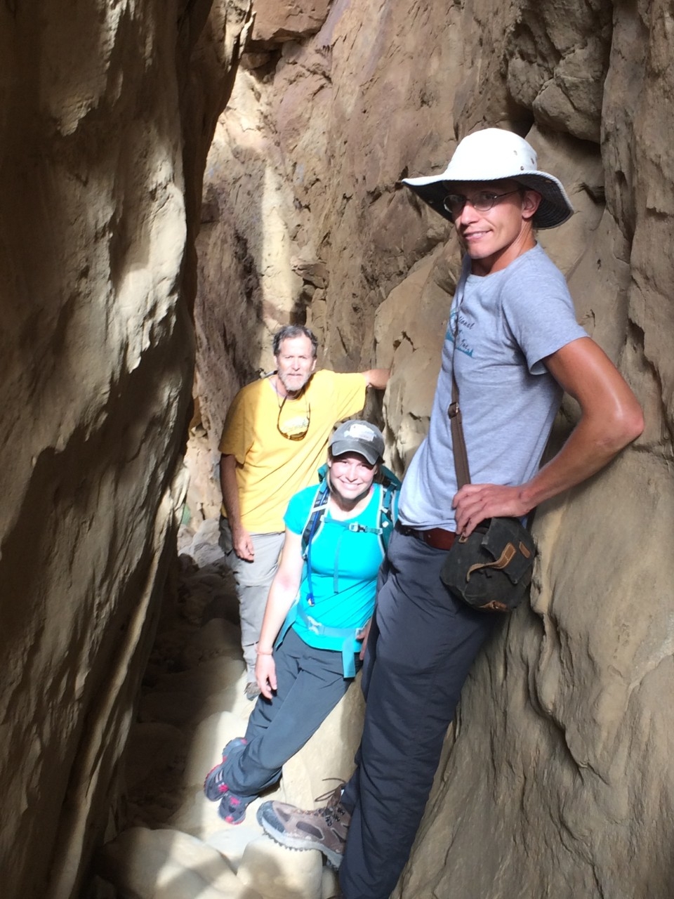 UC graduates Jon-Paul McCool, right, and Elizabeth Haussner hike a slot canyon with UC geography professor Christopher Carr. (Samantha Fladd) 