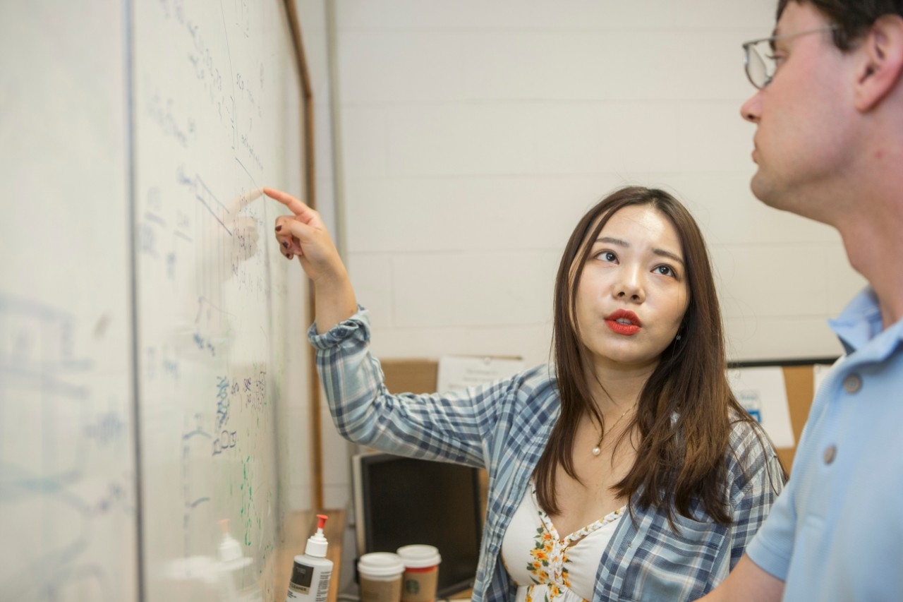 Chongqing University student Yixuan Zhang talks about an equation with her advisor while working on a research project at UC this summer. She will earn degrees from both universities this year.