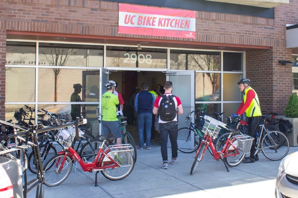 UC Bike Kitchen fix-it shop with bikes standing along the sidewalk.