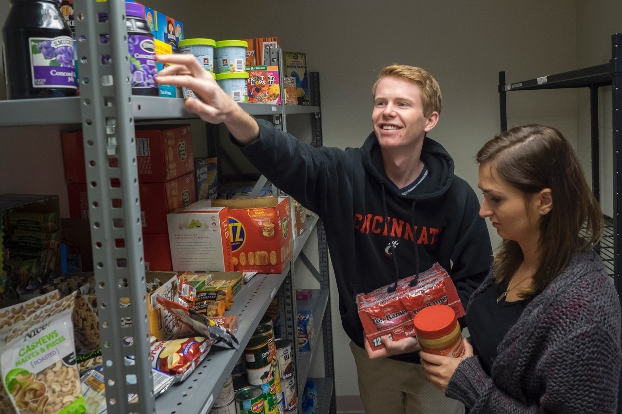 UC Food Pantry students stand near shelves of free food.