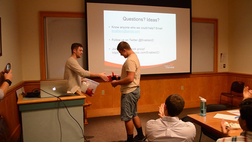 Prosthetic recipient T.J. McGinnis shakes Jacob Knorr's hand, utilizing his device created by EnableUC.