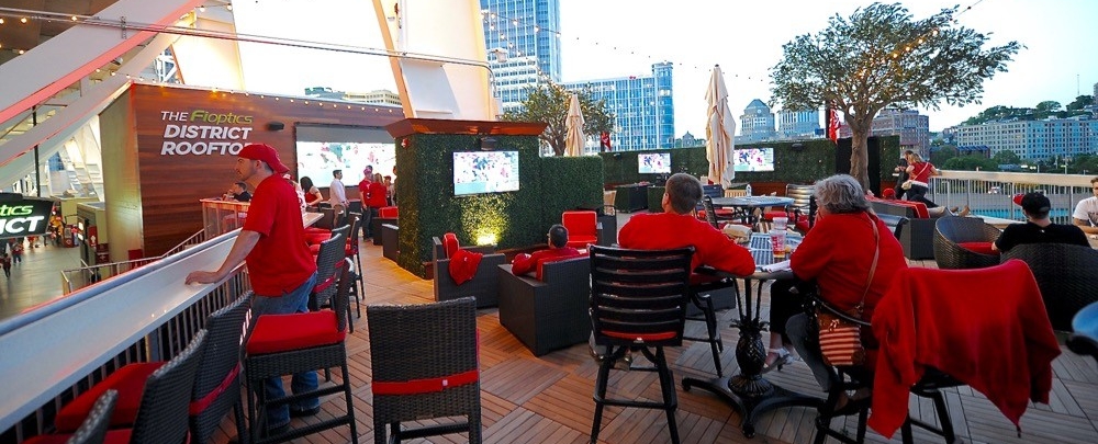 Men and women sit at tables and bar at Great American Ball Park