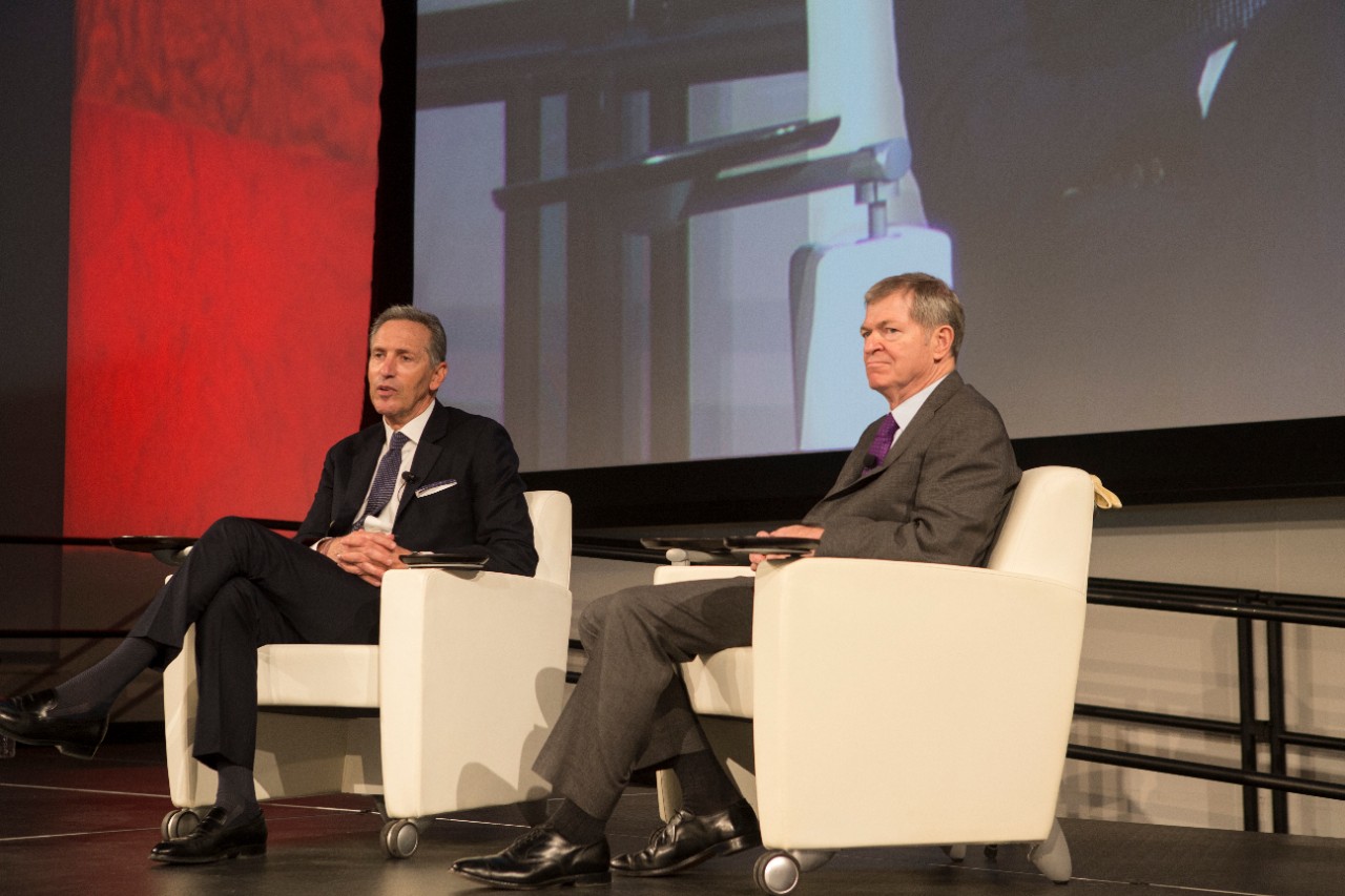 Starbucks Executive Chairman Howard Schultz, left, and former J.C. Penney CEO Myron Ullman III sit in chairs on a stage