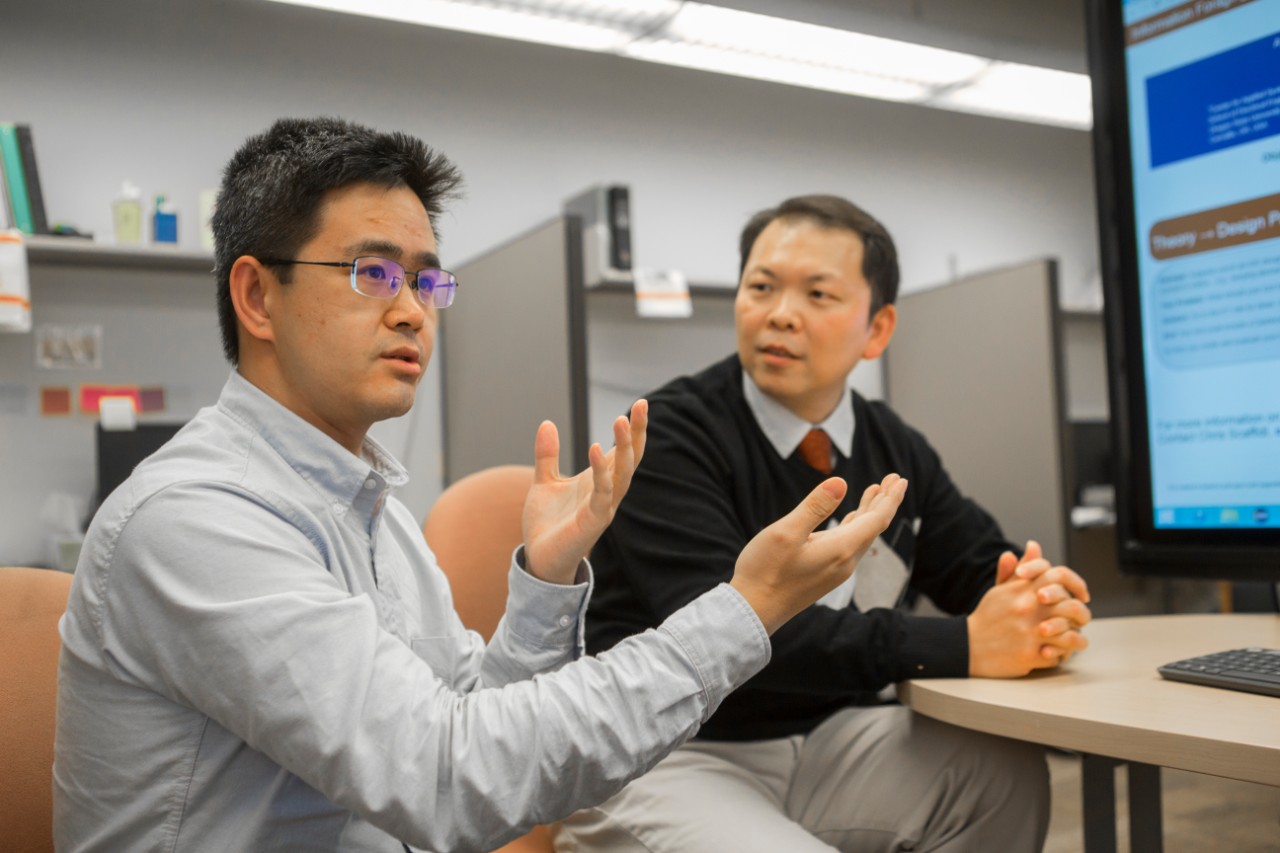 UC graduate student Xiaoyu Jin, left, and UC professor Nan Niu talk about their study of Internet foraging. Jin accepted a job in Silicon Valley after he graduates.