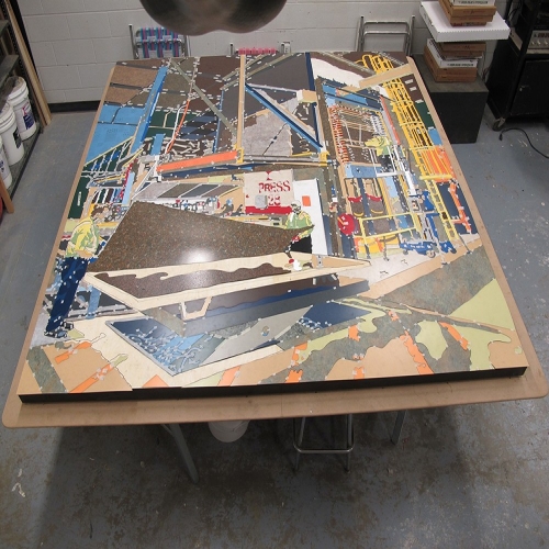 Each piece of the mural is taped down before the entire piece is glued and completed.