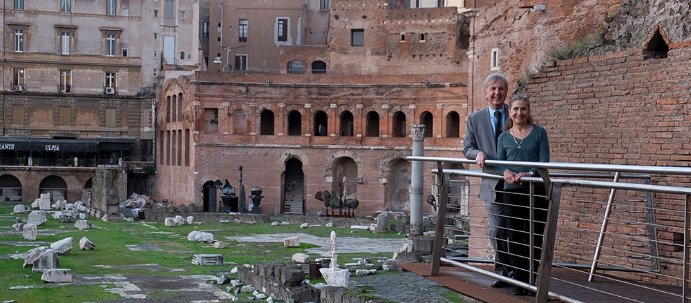 Jack Davis and Sharon Stocker stand in front of Roman ruins