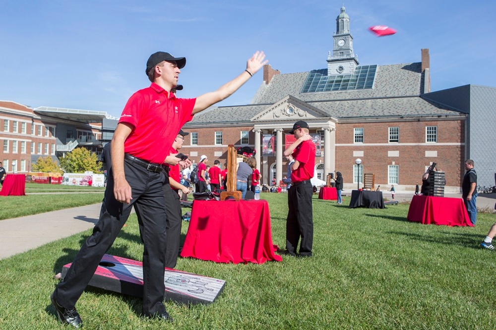 A member of the UC band takes part in cornhole game