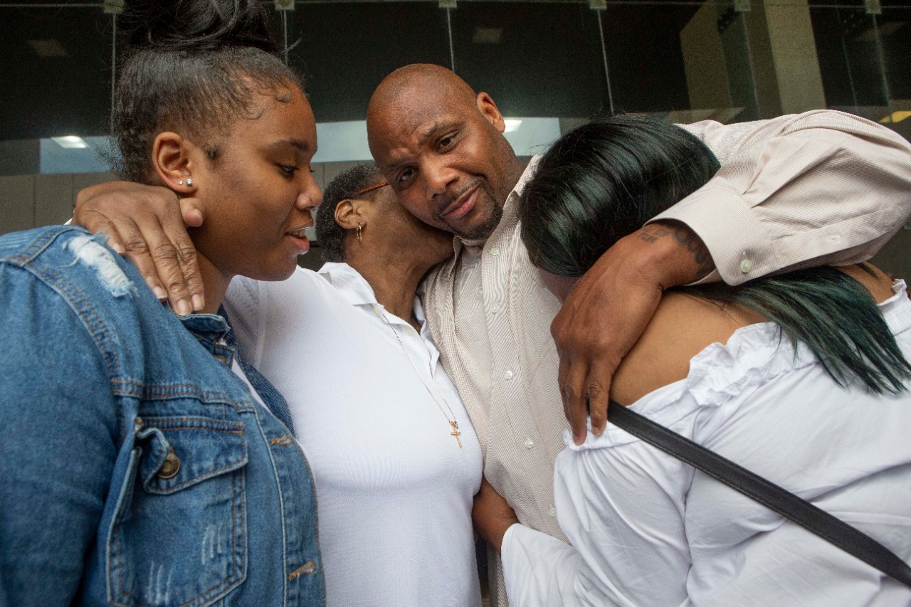 Family members hug Christopher Miller outside the Cuyahoga County Justice Center on Thursday after a judge ordered his 2002 convictions vacated.