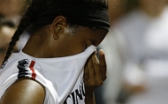 A University of Cincinnati woman's basketball athletic uses her jersey to wipe sweat off her nose.