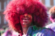 A University of Cincinnati student with a huge Afro hairstyle full of color from the 2015 Holi Festival.