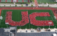 An overhead photo of a large group of students spelling the letters U and C for the University of Cincinnati