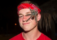 A University of Cincinnati student poses with a tarantula crawls across his face.