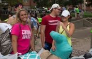 A smiling University of Cincinnati student moves into a dormitory