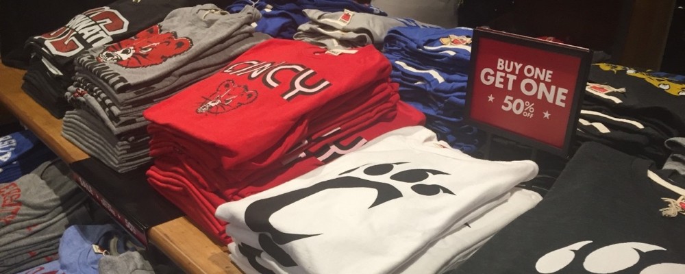 UC licensed T-shirts folded and displayed on a table.