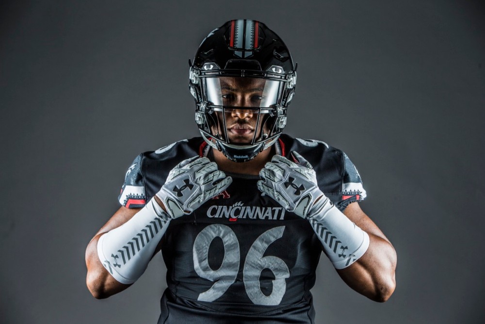 UC football player shows off Under Armour gear.