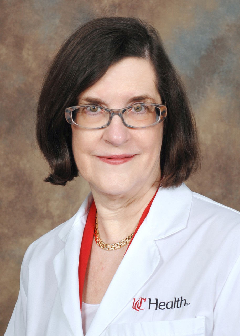 Dr. Elyse Lower poses for a headshot with glasses and a white UC Health lab coat.