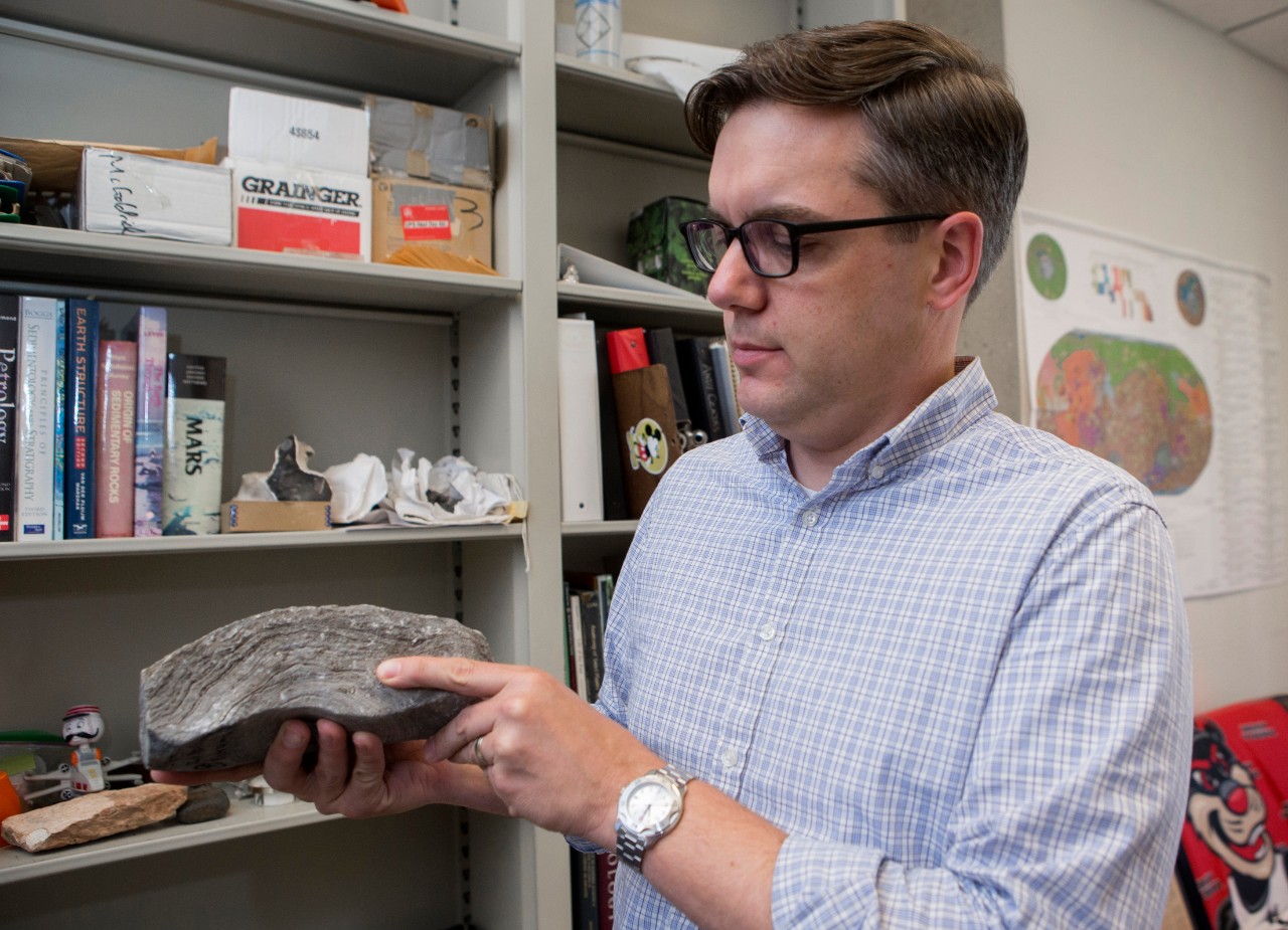 UC geology professor Andrew Czaja shows layering in a billion-year-old rock that suggests the presence of ancient life like the kind scientists will look for on Mars. 