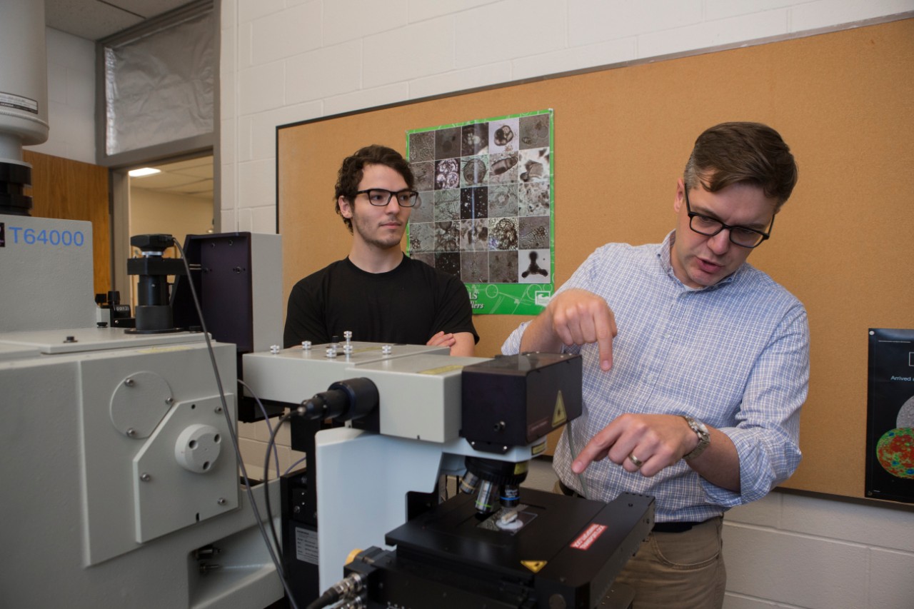 UC geology professor Andrew Czaja, right, and graduate student Andrew Gangidine use a spectroscopy machine in Czaja's lab.