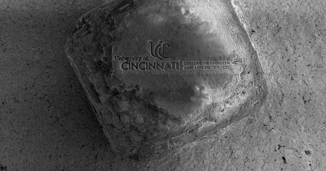 UC's Advanced Materials Characterization Lab used a dual-beam scanning electron microscope to etch UC's engineering college logo into a grain of salt.