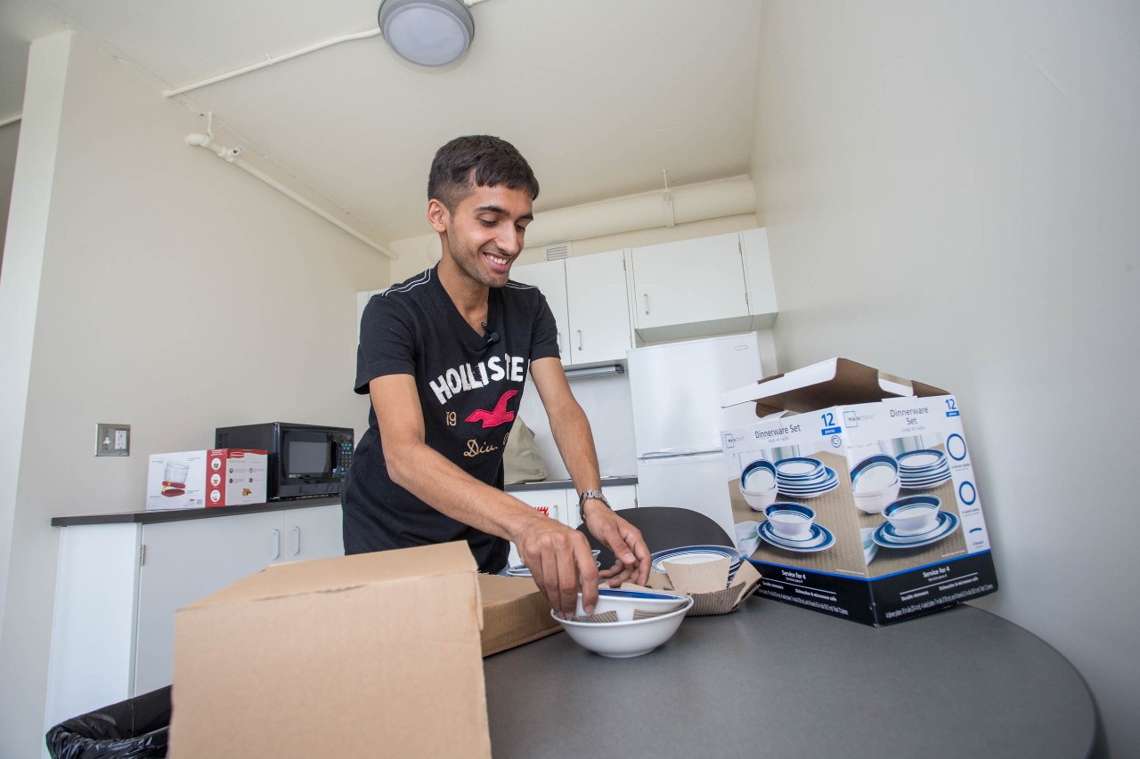 Sudarshan Pandey puts away dishes in his new home at Scioto Hall.