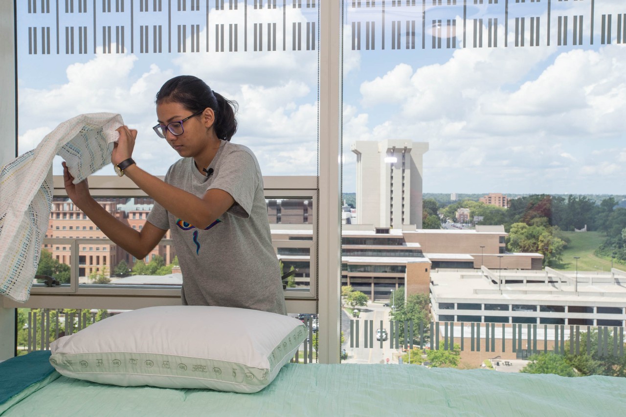 Pranita Dhungana makes her bed in her new home at Scioto Hall. Photo/Andrew Higley/UC Creative Services