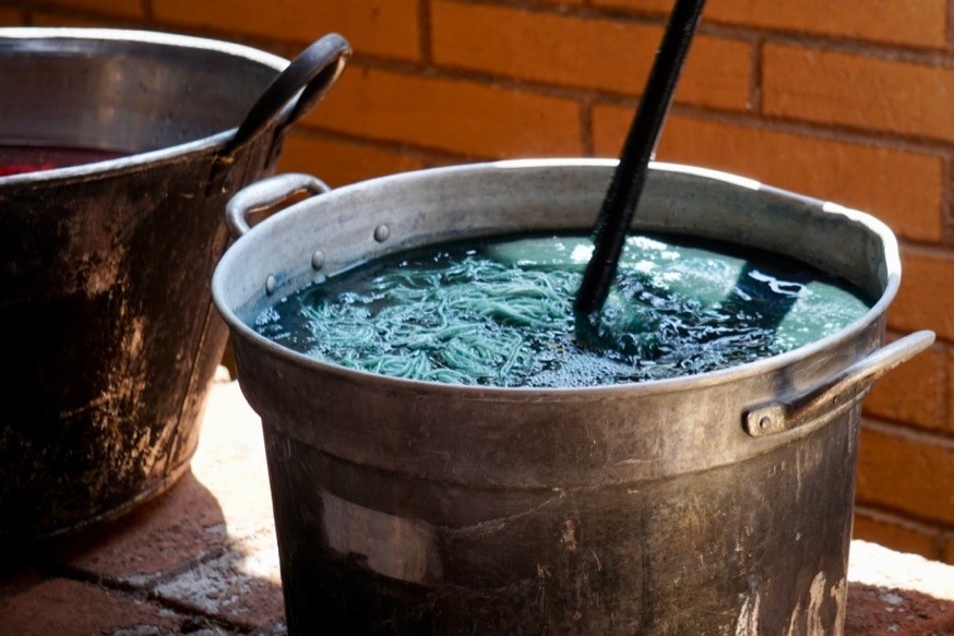 Threads of yarn soak in a pot of blue dye in Oaxaca, Mexico.