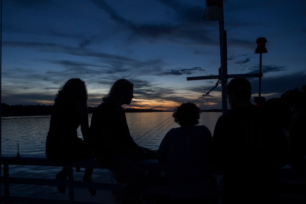 UC students ride along Amazon River at sunset.