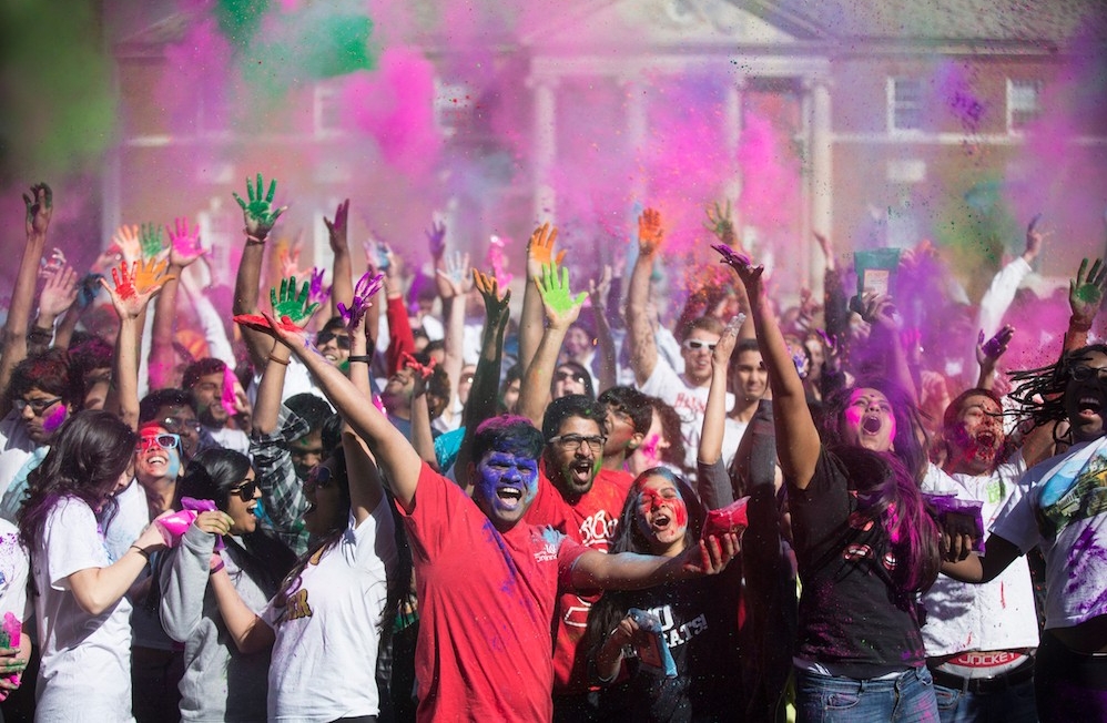 Student celebrate Holi Festival with throwing of colors on campus.