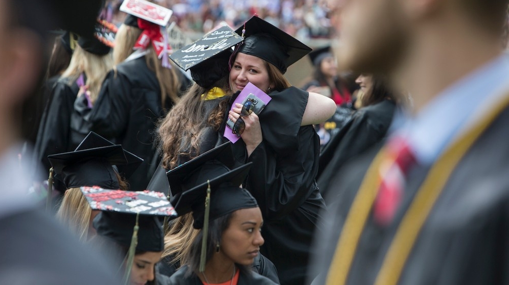 UC students embrace during Commencement in Nippert Stadium.