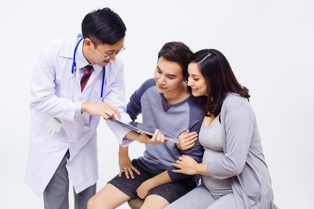 A doctor shows a pregnant woman and her husband information about TV's truth regarding pregnancy and childbirth. photo/Adobestock