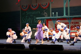 Leslie Kritzer, CCM '99, dances on the stage with the ball team.