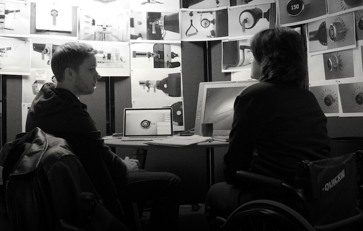 Ryan Eder meets with a consultant, who is in a wheelchair, in his studio