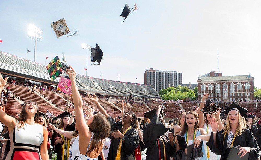 Graduates toss their caps in the air after Commencement