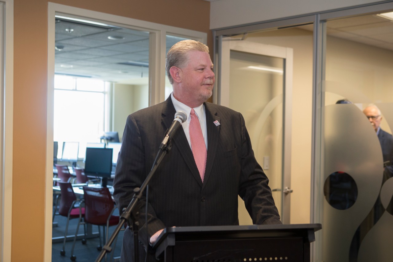 UC speaker at podium at the Staff Success Center ribbon cutting event.